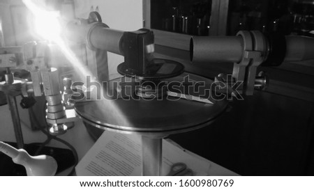 Experimental material of an optics laboratory in Toulouse, France : a goniometer with glass prism for spectral analysis, having autocollimator scopes and nonius, illuminated with a sodium lamp