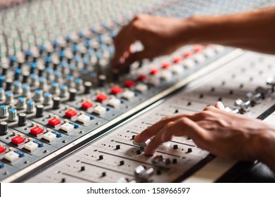 An Expert Adjusting Audio Mixing Console