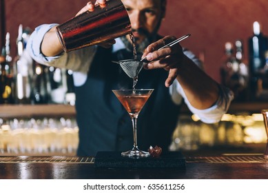 Expert barman is making cocktail at night club. - Shutterstock ID 635611256