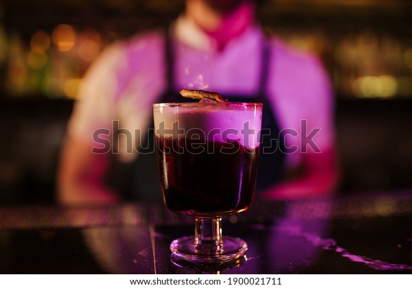 Expert barman is making cocktail at night club.\
Ready for drinking.
