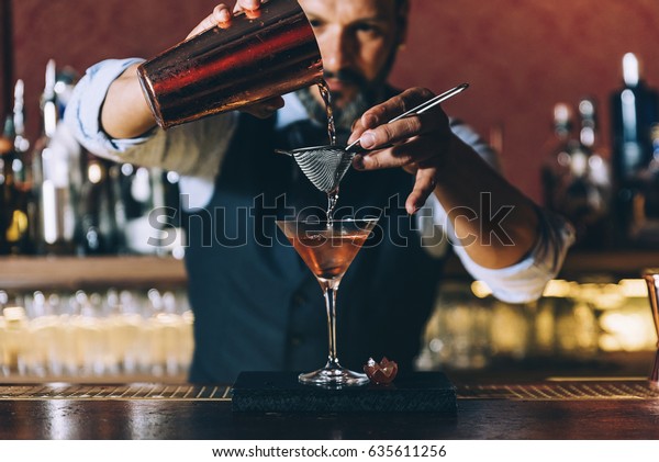 Expert barman is\
making cocktail at night\
club.
