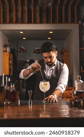 Expert bartender carefully adding a garnish to a crafted cocktail in a cozy bar setting