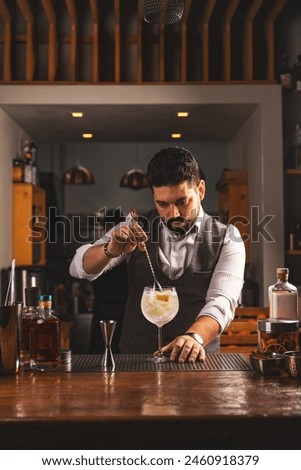 Expert bartender carefully adding a garnish to a crafted cocktail in a cozy bar setting