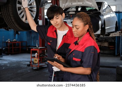 Expert Black female inspects repair checklist with automotive mechanic worker partner, quality suspension technician team at fix garage. Vehicle maintenance service works industry occupation jobs. - Powered by Shutterstock