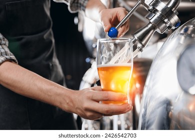 Expert brewer in apron holds glass and control quality of craft beer, banner with copy space. Sommeliers taste drink from brewery factory. - Powered by Shutterstock