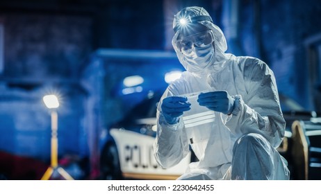 Expert Determining Potential Cause of Death While Bagging a Cartridge and Zipping it as Evidence. Forensics Specialist Finding Bullet Shell on Crime Scene at Night. Cold Toned Portrait Shot