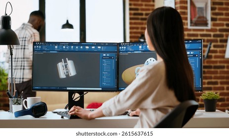 Expert engineer develops industrial prototypes using 3D modeling software at her home office, featuring dual monitors and modern office equipment perfect for innovative design processes. Camera B.