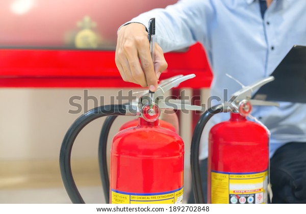 Expert engineers inspect fire extinguishers to be\
ready for use.