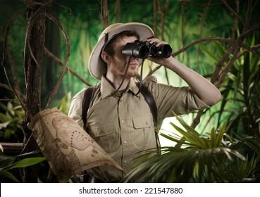 Expert explorer in the jungle looking away through binoculars.