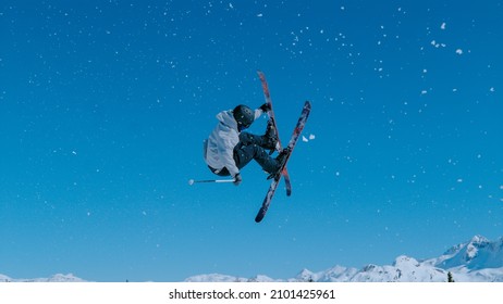Expert freestyle skier rides up a kicker and does a breathtaking trick on a sunny day. Athletic male tourist rides off a massive snowpark kicker in Vogel, Slovenia and does a spectacular 360 grab.
