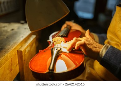 Expert luthier polishing the bridge of a violin in a well lit workshop, using a soft white cloth while focusing on the intricate details of the handcrafted instrument
