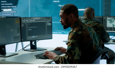 IT expert monitors AI brain intelligence system to collect crucial real time data for a new defense military operation on pc in command post. Security protocols for an intense mission. Camera A. - Powered by Shutterstock