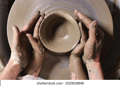 An expert potter, he creates with clay and his hands a beautiful vase in his laboratory. The artisan creates works of art with his hands. Concept of: experience, art, tradition, clay.