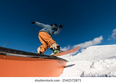Expert snowboarder balancing and executing tricks on the wallride.