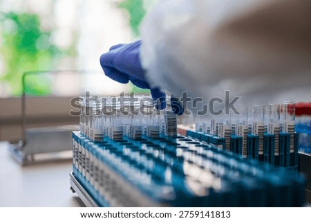 Expert Technician Systematically Handling Laboratory Vials In Sterilized Environment For Testing Purposes