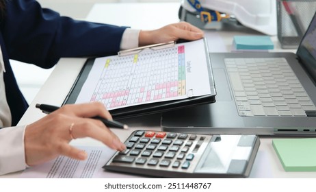 Expert woman asian female people review data number costing managerial account prepare monthly actual cost variance report at tax audit office. ESG sheet budget control ERP process service project. - Powered by Shutterstock