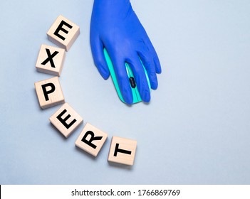 Expert Word Written On Wood Block. Doctor Hand In Glove On Computer Mouse. Medical Expert Concept