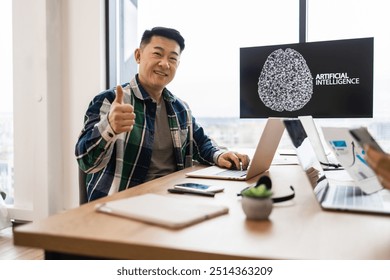 IT expert working on developments of artificial intelligence in modern office setting, giving thumbs up. Professional tech workspace with laptops, smartphone, and digital display showing AI concept. - Powered by Shutterstock