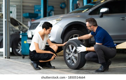 Expertise mechanic man showing the tread of a old tire to a female customer at Car maintenance and auto service garage - Powered by Shutterstock