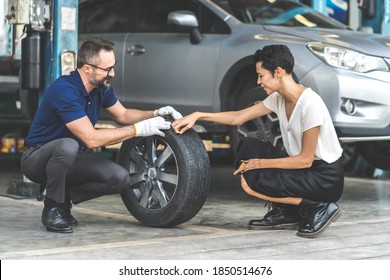 Expertise mechanic man showing the tread of a old tire to a female customer at Car maintenance and auto service garage - Powered by Shutterstock