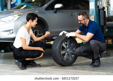 Expertise mechanic man showing the tread of a old tire to a female customer at Car maintenance and auto service garage - Powered by Shutterstock