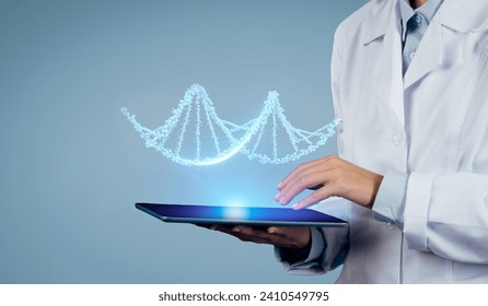 Expertise meets technology: close up shot of doctor wields CRISPR and augmented reality to decode the secrets of virtual DNA for patients on digital tablet, blue studio background, free space