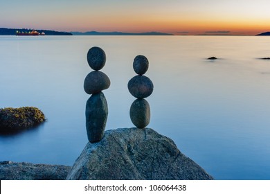 Expertly balanced stones on a Vancouver shoreline at sunset