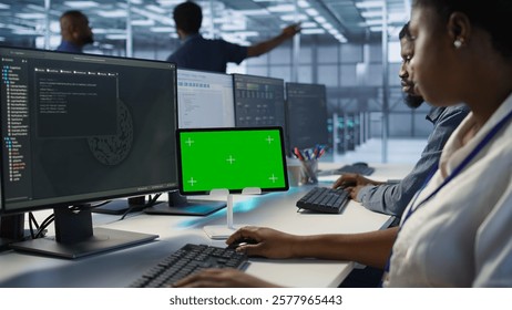 IT experts using green screen tablet, working together in server farm to optimize it for data processing requirements. Close up of coworkers coding on chroma key device in data center, camera A