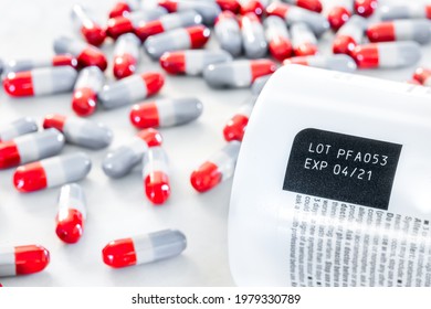 Expired date and lot number label print on medicine bottle with blurred background of pile of painkiller pills on table, awareness expiration information from pharmaceutical manufacturer. Medication.