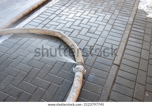 Expired Fire Hose ,\
water leaking. water leaking from hole in a industrial hose. \
fire\
hose lies on the street