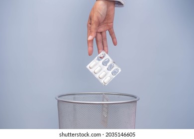Expired medicine. Woman's hand throws expired medicine in the trash. improper disposal of the drug Medicines should not be placed in trash or water sources.