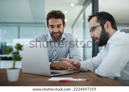 Explaining the best strategy. Shot of two businessmen having a meeting in an office.