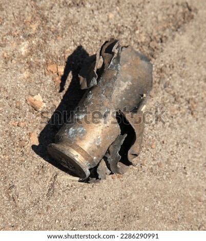 Exploded and burnt cartridge case after shot. Battlefield and the remnants of weapons ammunition close-up. War in country