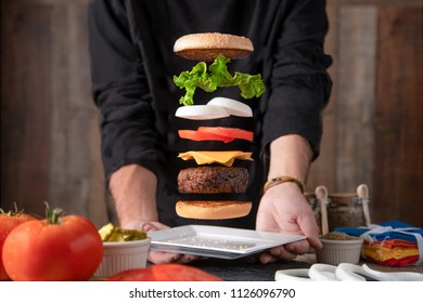 Exploded view of a cheeseburger above a plate being held by a man. Levitating Cheeseburger.
