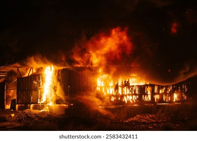 Exploding warehouse. Burning industrial building. Big blaze at night.