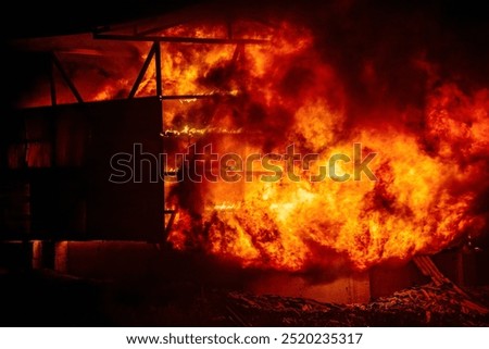 Exploding warehouse. Burning industrial building. Big blaze at night.