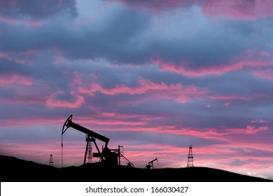 Exploited Oil Field On Sunset With Silhouettes