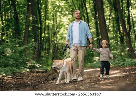 Exploration conception, walking together. Father with son and dog are in the forest.