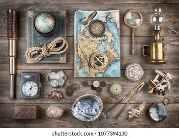 Exploration and nautical theme grunge background. Compass, telescope, sextant, divider, old coins, rope, shell, map, globe, magnifier, hourglass on wood desk. Retro style.