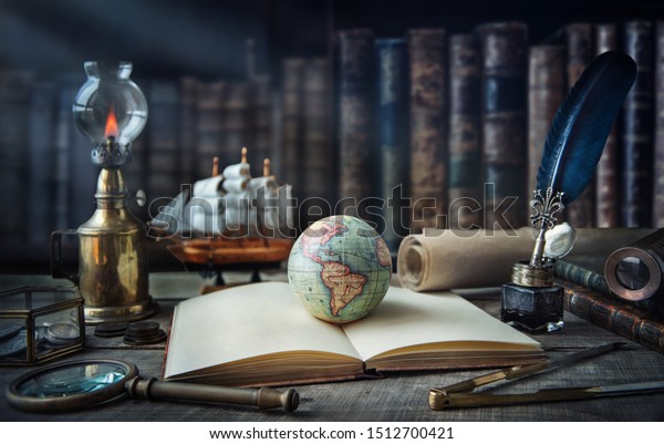 Exploration and nautical theme grunge\
background. Globe, telescope, divider, old coins, shell, map, book,\
hourglass, quill pen on wood desk. Columbus Day.\
