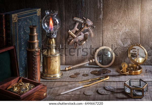 Exploration and\
nautical theme grunge background. Compass, telescope, sextant,\
coin, divider and old book on wood\
desk
