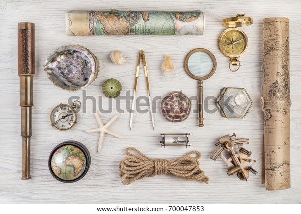 Exploration and nautical theme
grunge background. Compass, telescope, sextant, divider, old coins,
rope, shell, map, globe, magnifier, hourglass on wood desk. Retro
style.