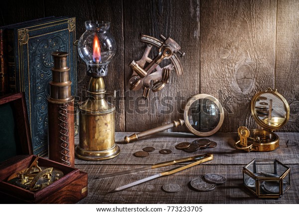Exploration and\
nautical theme grunge background. Compass, telescope, sextant,\
coin, divider and old book on wood\
desk.