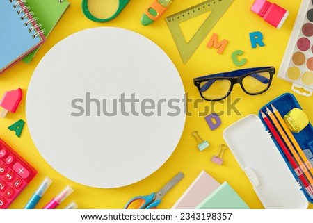 Explore the realm of education. Top view arrangement of spectacles, assorted school materials, colorful letters on yellow background with blank circle for promo or text