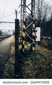 Explore the Rustic Allure of a Railway Track with a Striking Yellow-Black Signal Tower.