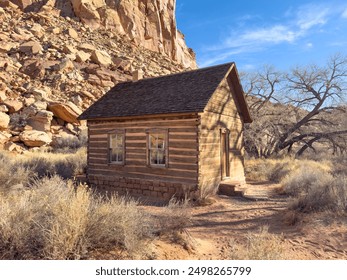 Explore the rustic beauty of an abandoned wooden cabin nestled in the Arizona desert, surrounded by rugged rock formations and dry vegetation under a clear blue sky. - Powered by Shutterstock