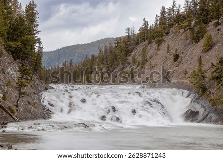 Explore the stunning Bow Falls in Banff National Park, Alberta, Canada, a breathtaking waterfall amidst the Canadian Rockies.