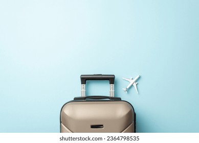 Explore the world by plane. Top-down view of a miniature airplane model, and stylish luggage on a soft pastel pink backdrop, perfect for promotional content