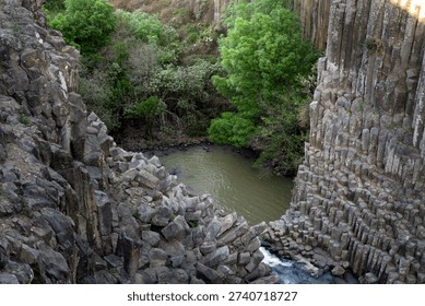Exploring basalt prisms at a river in Hidalgo Mexico surrounded by green trees