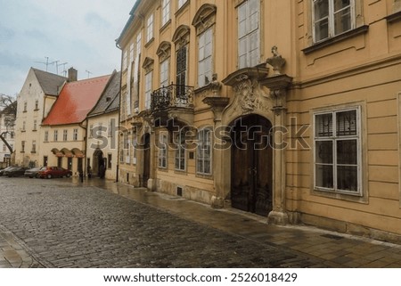 Exploring the charming streets of Bratislava on a rainy day with historic architecture and quaint buildings lining the cobblestone walkway